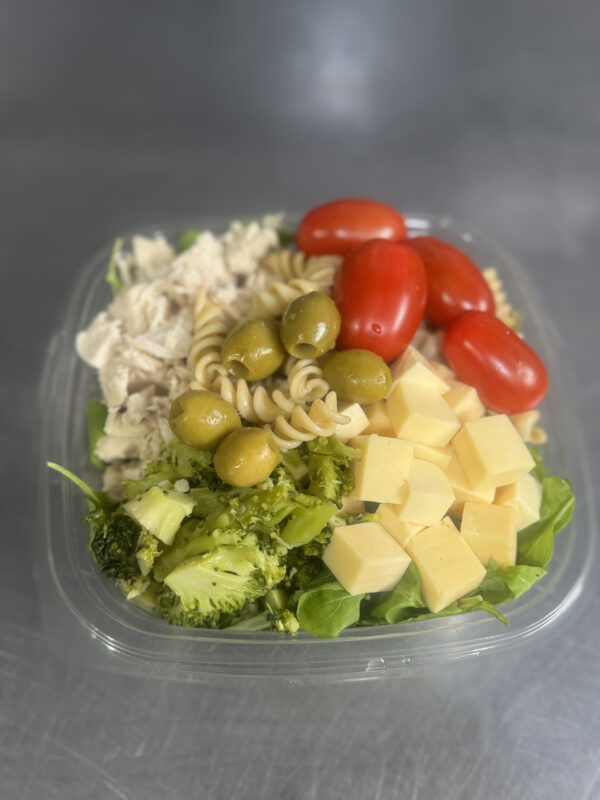 Ensalada Pasta: Rúcula, fideos tirabuzón, pollo en tiras, queso en cubos, tomate cherry, brócoli, aceitunas y crutones